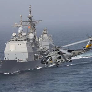 A SH-60J Seahawk flys by USS Vicksburg during a vertical replenishment