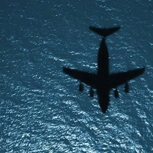 Silhouette of a military aircraft in flight over the Atlantic Ocean
