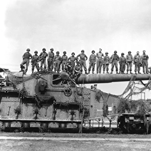 U. S. Army soldiers stand on top of a large 274mm railroad gun