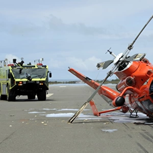 A U. S. Coast Guard MH-65 Dolphin helicopter lays on its side after it crashed at