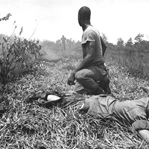 A young American lieutenant is treated by a medic in Vietnam, 1966