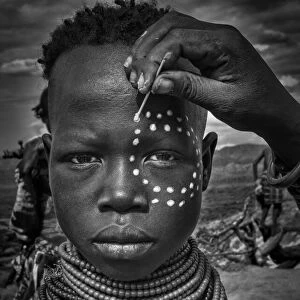 Painting the face of a karo tribe girl (Omo Valley-Ethiopia)
