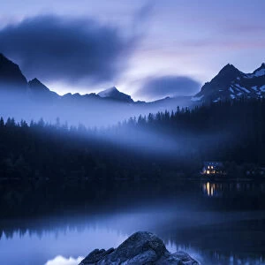 Popradske Pleso, looking toward mountain range, in late evening light, with reflections and mist