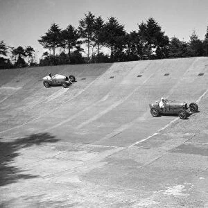 Two Bugatti Type 35s racing on the Members Banking at Brooklands. Artist: Bill Brunell