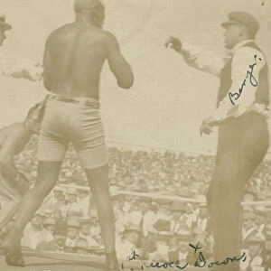 Photographic postcard of James J. Jeffries staggering away from Jack Johnson, 1910