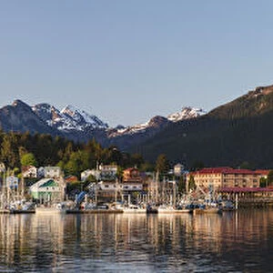 Downtown Sitka And The O connell Bridge On A Clear Summer Evening, Sitka Harbour And Docked Fishing Boats In The Foreground, The Sisters Mountains With Snow On The Peaks In The Background; Sitka, Alaska, United States Of America