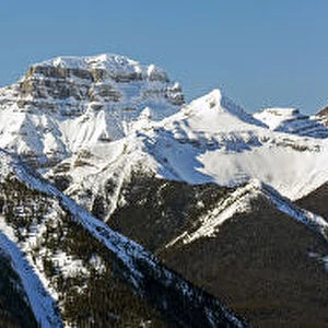 Panorama of snow-covered mountain range and blue sky