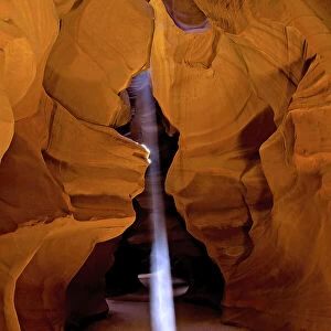 Shaft of light creates a glowing beam in a slot canyon, USA