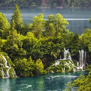 Waterfalls with turquoise water surrounded by trees at the Plitvice Lakes National Park in Lika-Senj county in Croatia