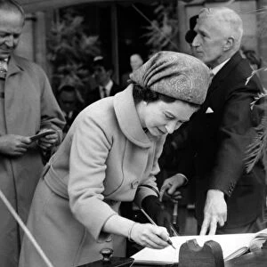 Alderman John grundy steadies the page as Queen Elizabeth II signs the visitors book
