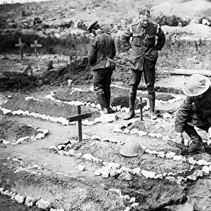 An army chaplain tending to a British soldiers grave in 1916 in France after the Battle