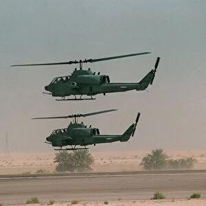 Two US Army Cobra gunships Oct 1990 hover over airfield during the Gulf War