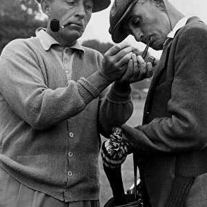 Bing Crosby and caddie break for a smoke during golf 1952