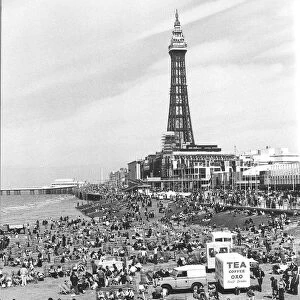 Blackpool Tower with people sitting on Blackpool Beach