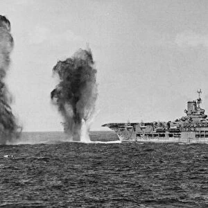Bombs falling astern of HMS Ark Royal during an attack by Italian aircraft during