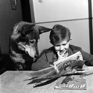 Boy reading a comic with his pet dog December 1952 C5868