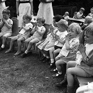 Children saying prayers before dinner time at a nursery in England during the war