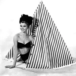 Clothing Beach 1963. Model Merril Weston shows how to use the striped cape-tent
