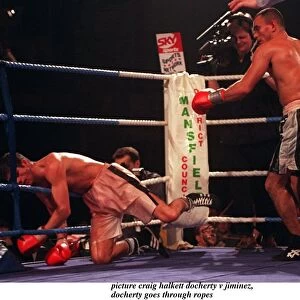 Daniel Jiminez of Puerto Rico punches Drew Docherty of Scotland through the ropes
