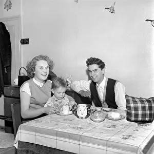 Family life: Mr. and Mrs. Hull giving their son his tea. 1954 A160-002