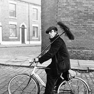 Fred Gibson chimney sweep riding bike on his round 1965 in Chadderton Lancs
