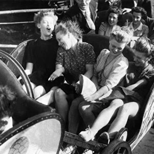 Four friends enjoy a fairground ride during the August Bank Holidays. August 1946 P000019