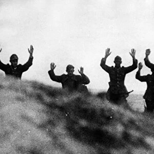 Germans, former "Herrenvolk", come over the crest of a hill with their hands