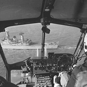 The helicopter heads towards the landing platform on the stern of HMS Aurora during a