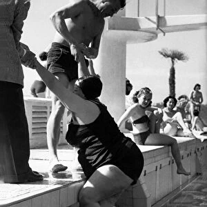Helping Hands A large lady is helped out of the outdoor swimming pool at Plymouth