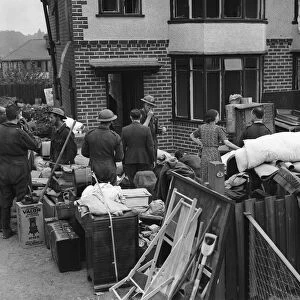 Householders and ARP recovery squad removing furniture from their bomb damage home in