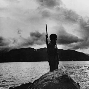 A US Marine looks out across the waters towards of the Aleutian Islands