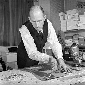 Mens Fashions: Tailor measuring and sewing in his workshop