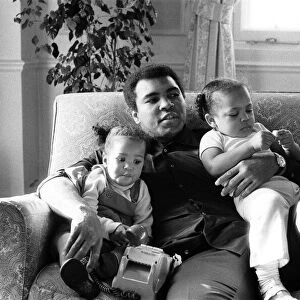 Muhammad Ali cuddling his daughters Laila, (left )and Hana (right