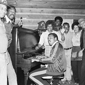 Muhammad Ali at his training camp, enjoys a sing song with those who work for him on 2nd