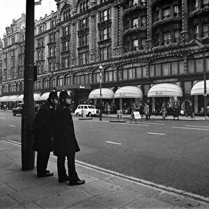 Police in twos keep an eye on Harrods as the last minute shoppers get Christmas