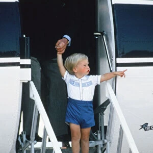 Prince Charles helping a young Prince William down the steps of the aircraft after