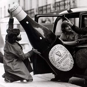 Ron Nicholson (left) Bill Barnard trying to get a large bottle of Guinness into a London