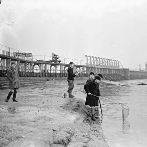Schoolboys fishing at Teddington Weir during the winter drought of 1933