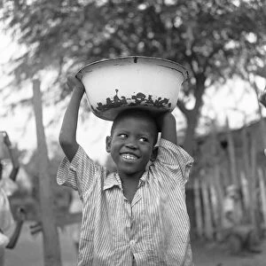 A small boy seen here carrying water from the local standpipe home in Jonestown, Kingston