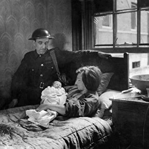 Warden Bill Watson at the bedside of Mrs. R. Foster. With bombs falling round