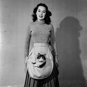 Women seen here modelling the Hold-All apron with her pet cat. December 1952 C6269