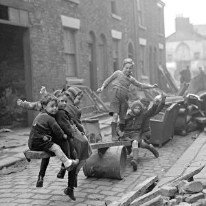 WW2 Children Playing Games Children make a see-saw out of an upturned dustbin