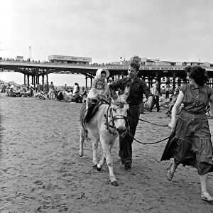 A young holiday makers having a Donkey ride on the beach at Blackpool, Lancashire