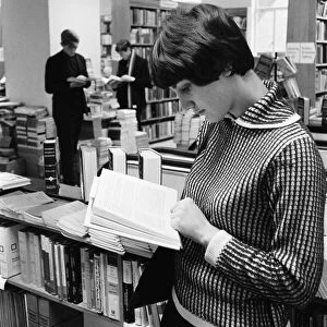 Young lady reading a text book in the Technical book department at Foyles bookshop in