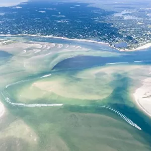 Small boats navigate a channel between sand islands on Cape Cod, Massachusetts. This beautiful area of New England is a popular vacation destination