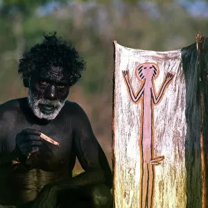 Australia. Arnheim Land: aborigine paints a picture on tree bark