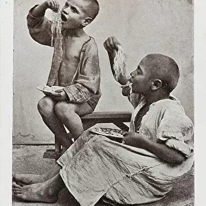 Costumes of Naples. Portrait of two children eating a plate of spaghetti with their hands, postcard
