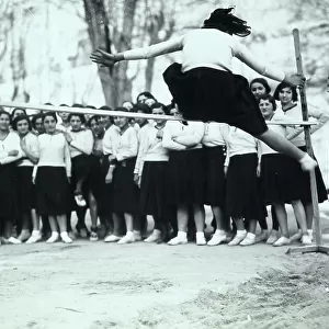 Group of youth gymnasts during the Fascist period. A girl is testing herself in the high jump
