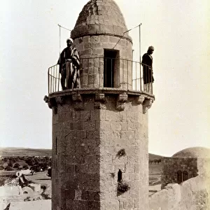 Two muezzin are calling the faithful to prayer from the top of a minaret