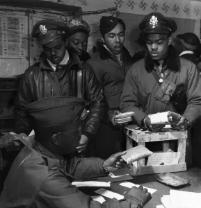 Fighter pilots of the Tuskegee Airmen 332nd Fighter Group receive 'Escape kits' (cyanide) at Ramitelli Airfield, Italy. Photograph by Toni Frissell, March 1945. Seated: Theodore Lumpkin, Jr. Standing, left to right: Joseph Chineworth, Robert Robinson, Driskell Ponder, Robert Williams Fighter pilots of the Tuskegee Airmen 332nd Fighter Group receive 'Escape kits' (cyanide) at Ramitelli Airfield, Italy. Photograph by Toni Frissell, March 1945. Seated: Theodore Lumpkin, Jr. Standing, left to right: Joseph Chineworth, Robert Robinson, Driskell Ponder, Robert Williams
